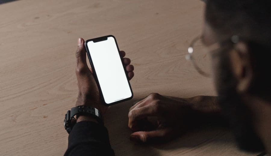 Person holding a phone at a wooden table